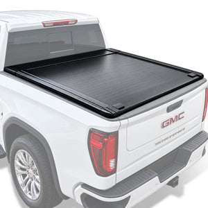 A black truck bed cover installed on the bed of a white GMC Sierra pickup truck, shown from a rear three-quarter angle against a clean white background.