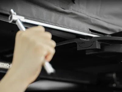 Hand using a wrench on a car engine with a blurred background