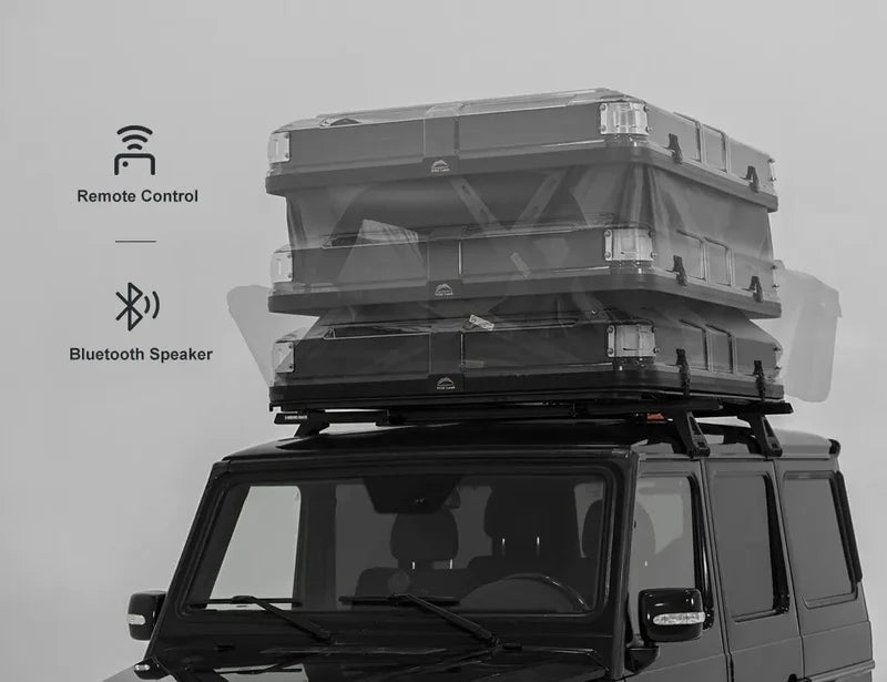 Roof rack with storage boxes on a vehicle, featuring remote control and Bluetooth speaker icons.