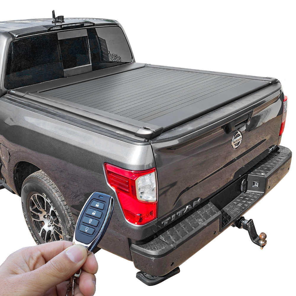 Gray Nissan Titan truck with a ER Retractable PRO tonneau cover and a hand holding a key fob on a white background