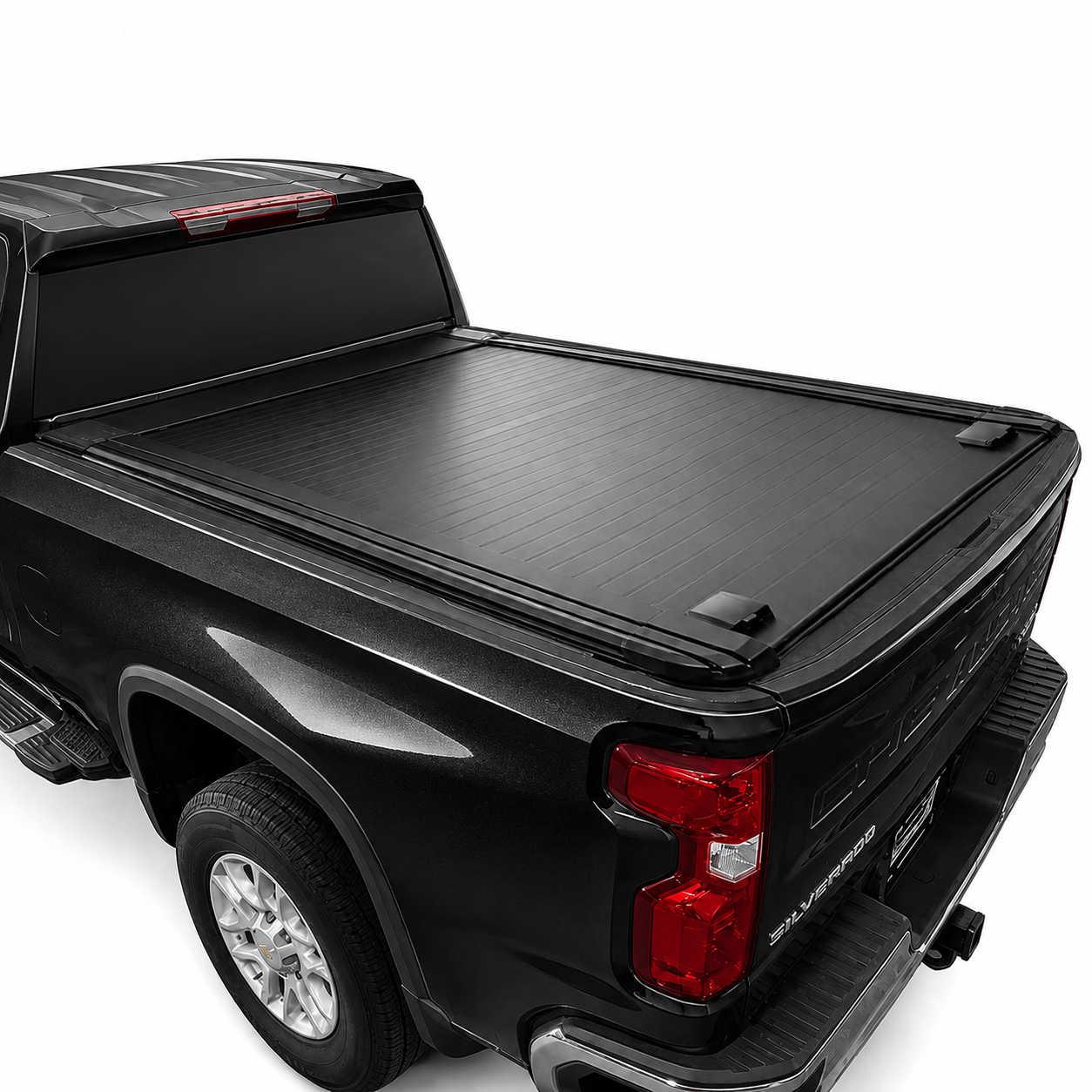 A black roll-up truck bed cover installed on the bed of a black pickup truck, shown from a rear three-quarter angle against a white studio background.