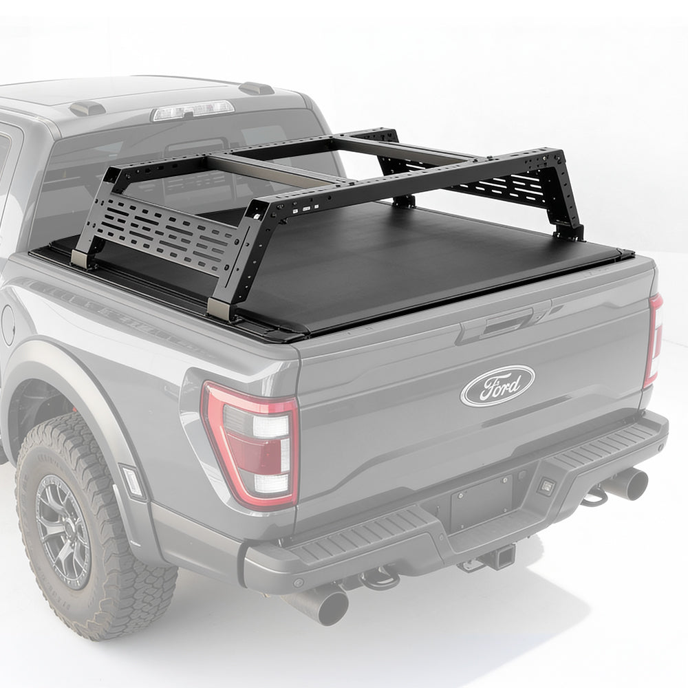 Gray Ford truck with a black tonneau cover and roof rack on a white background