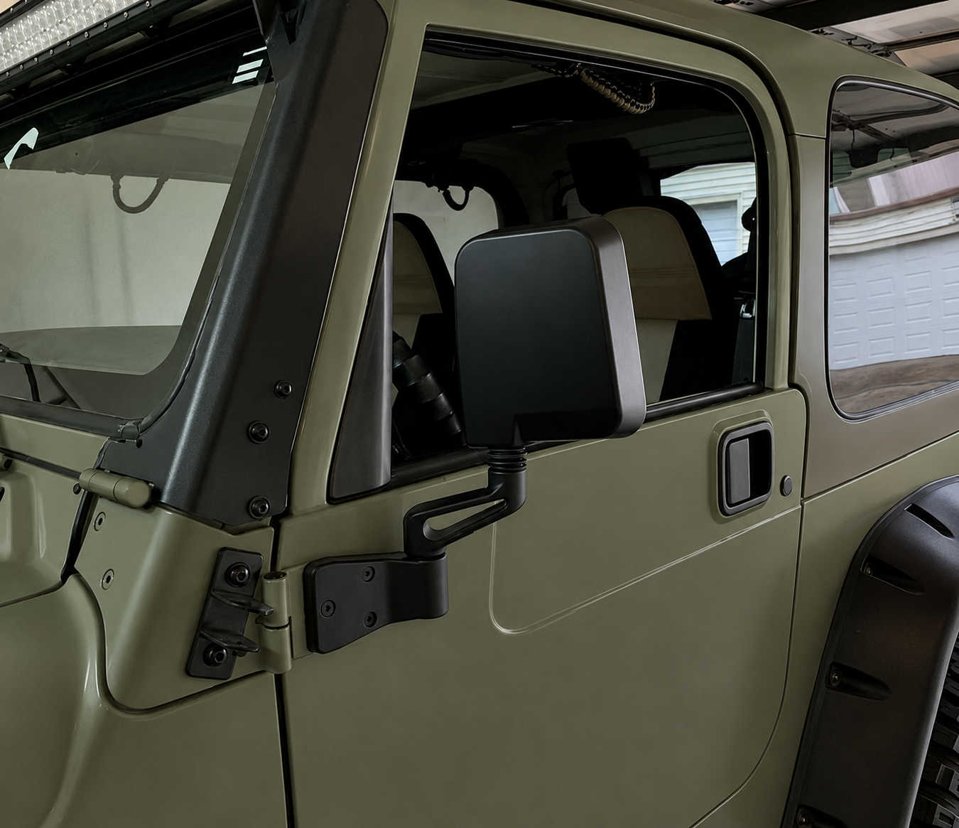 Close-up of a green off-road vehicle door with window and side mirror installed