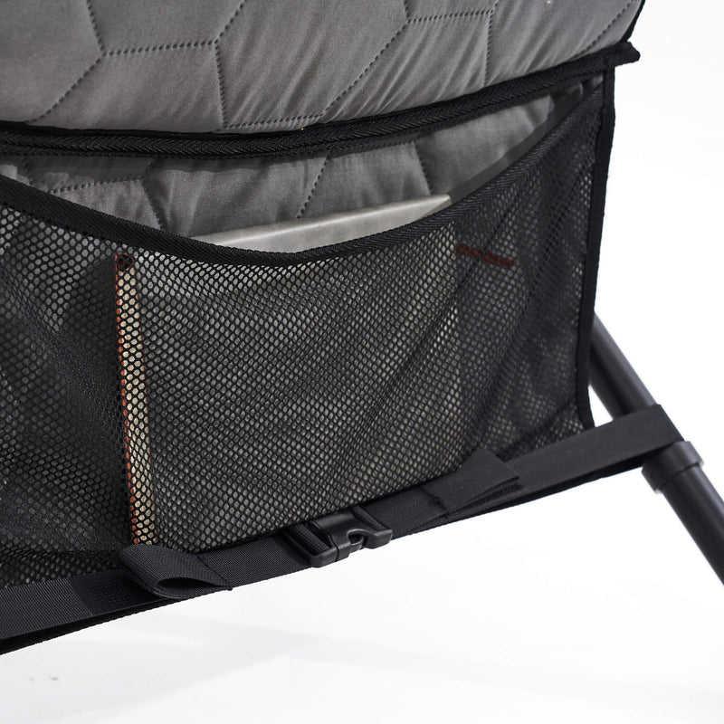 Close-up of a gray quilted bag with a black mesh pocket on a white background