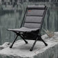 Gray camping chair on a rock by a body of water