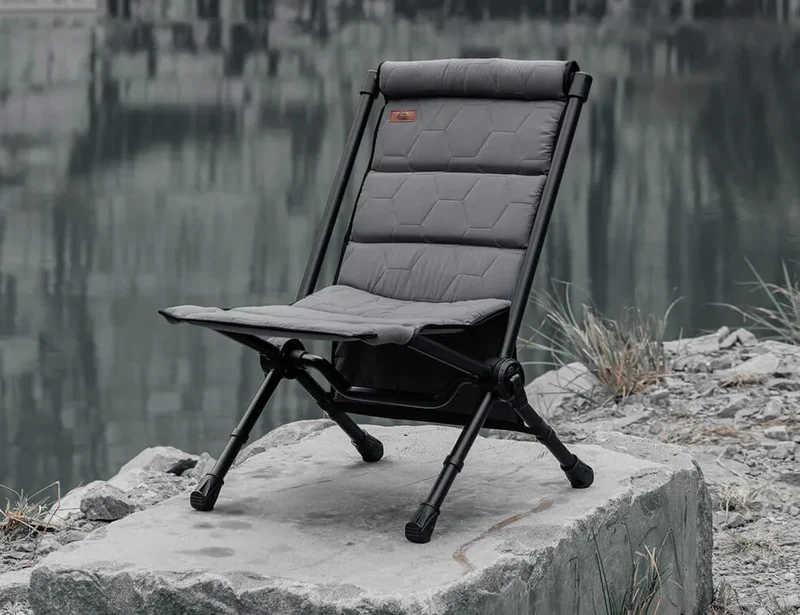 Gray camping chair on a rock by a body of water