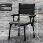 Black camping chair with measurements and weight displayed on a rocky ground.