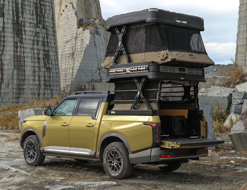 Yellow SUV with a rooftop tent in a rocky outdoor setting