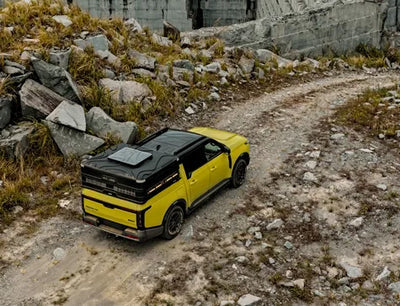 Yellow off-road vehicle on a rocky path with stone walls in the background