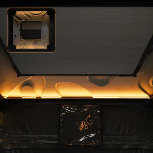 Close-up of a black electronic device with gold accents on a dark background