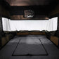 Bed inside a vehicle with a canopy and window in the background