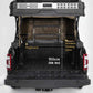 Back of a vehicle with a bamboo folding table and pegboard system, showing dimensions.