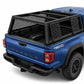 A blue Tacoma pickup truck shown from the rear three-quarter angle, fitted with a black flex modular cap, basecamp and side racks on a clean white studio background brand syneticusa