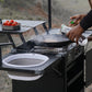 Portable camping stove with a frying pan and tomatoes outdoors