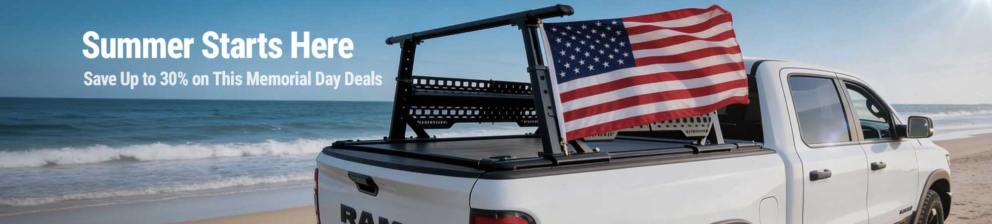 White truck with a bed rack on a beach at night, fireworks in the sky.