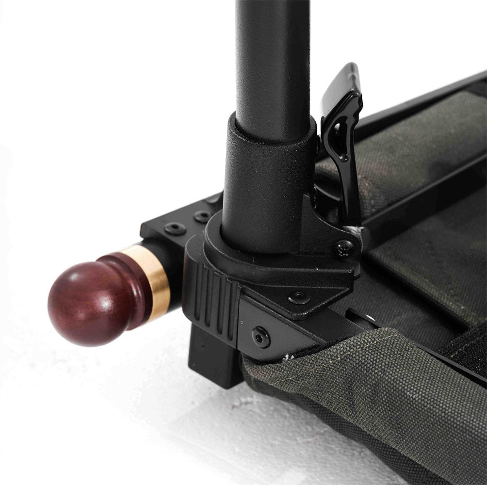 Close-up of a folding chair or bench leg assembly with a black metal frame, green fabric sling, and a dark reddish-brown wooden ball finial on a white background.