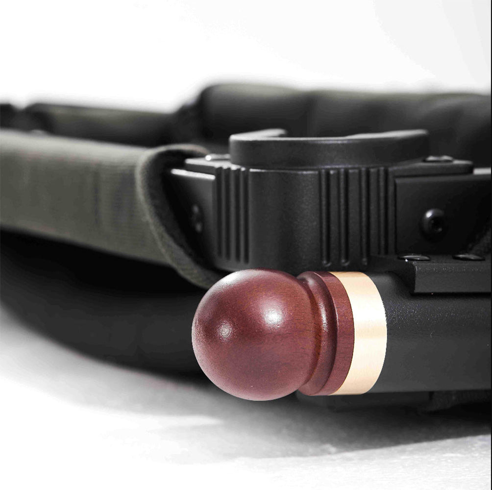 Close-up of a round reddish-brown wooden knob and a metallic gold accent ring.