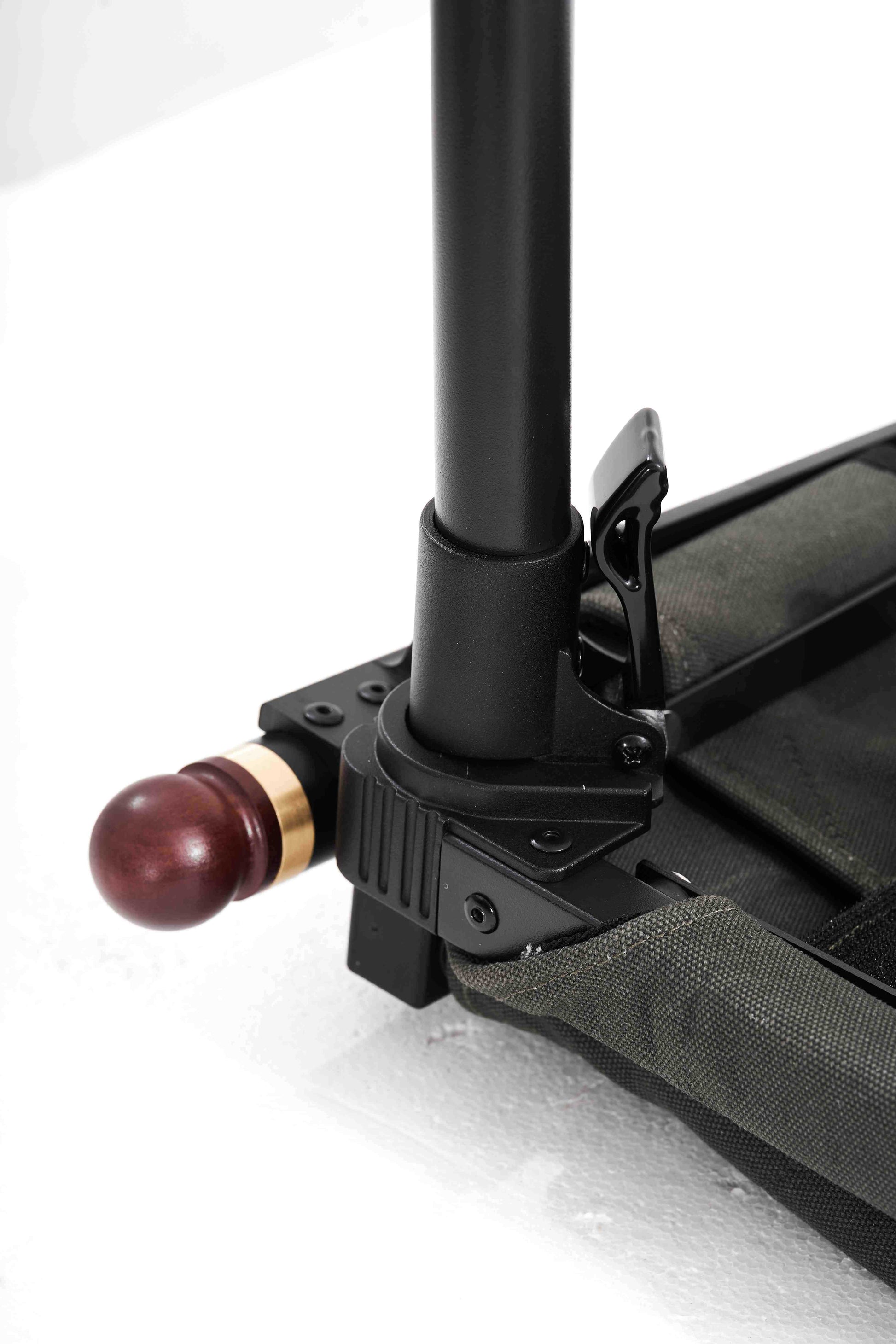 Close-up of a black metal stand with a wooden ball on a white background