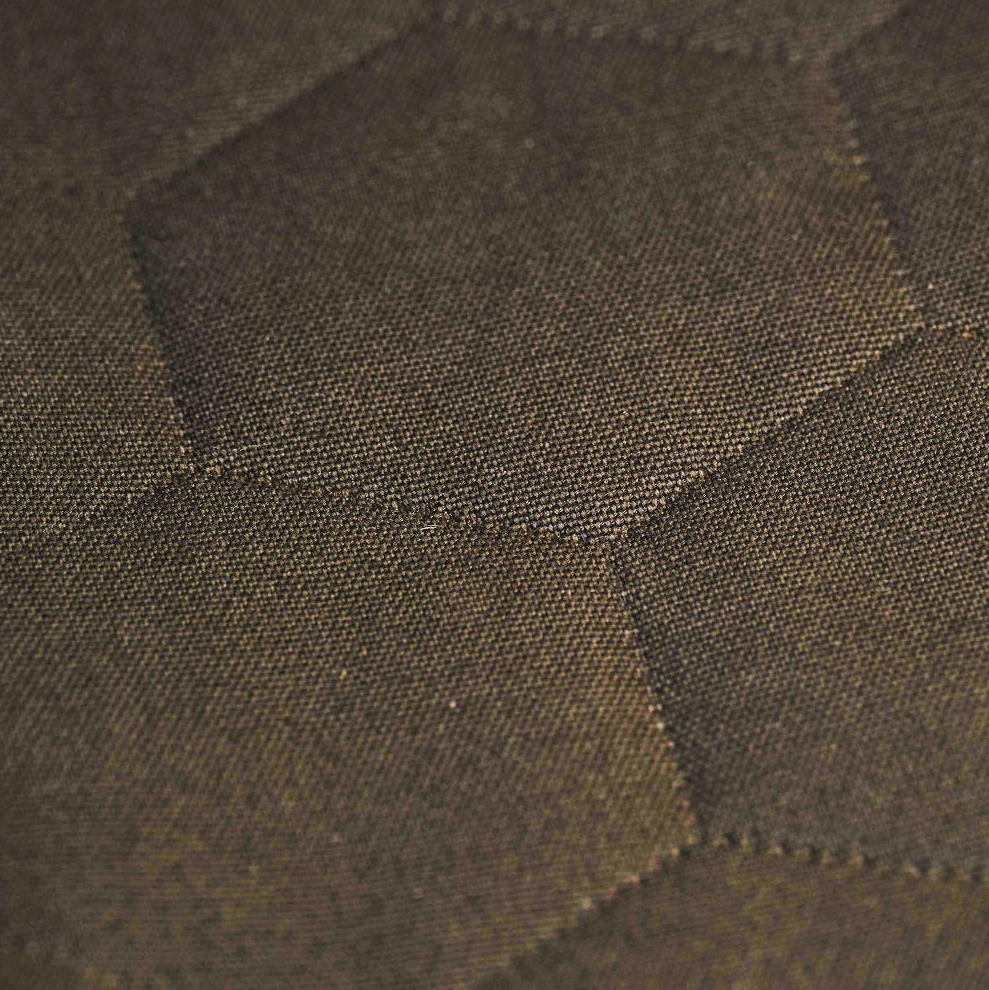 Close-up of green textured fabric with a subtle geometric hexagonal pattern.