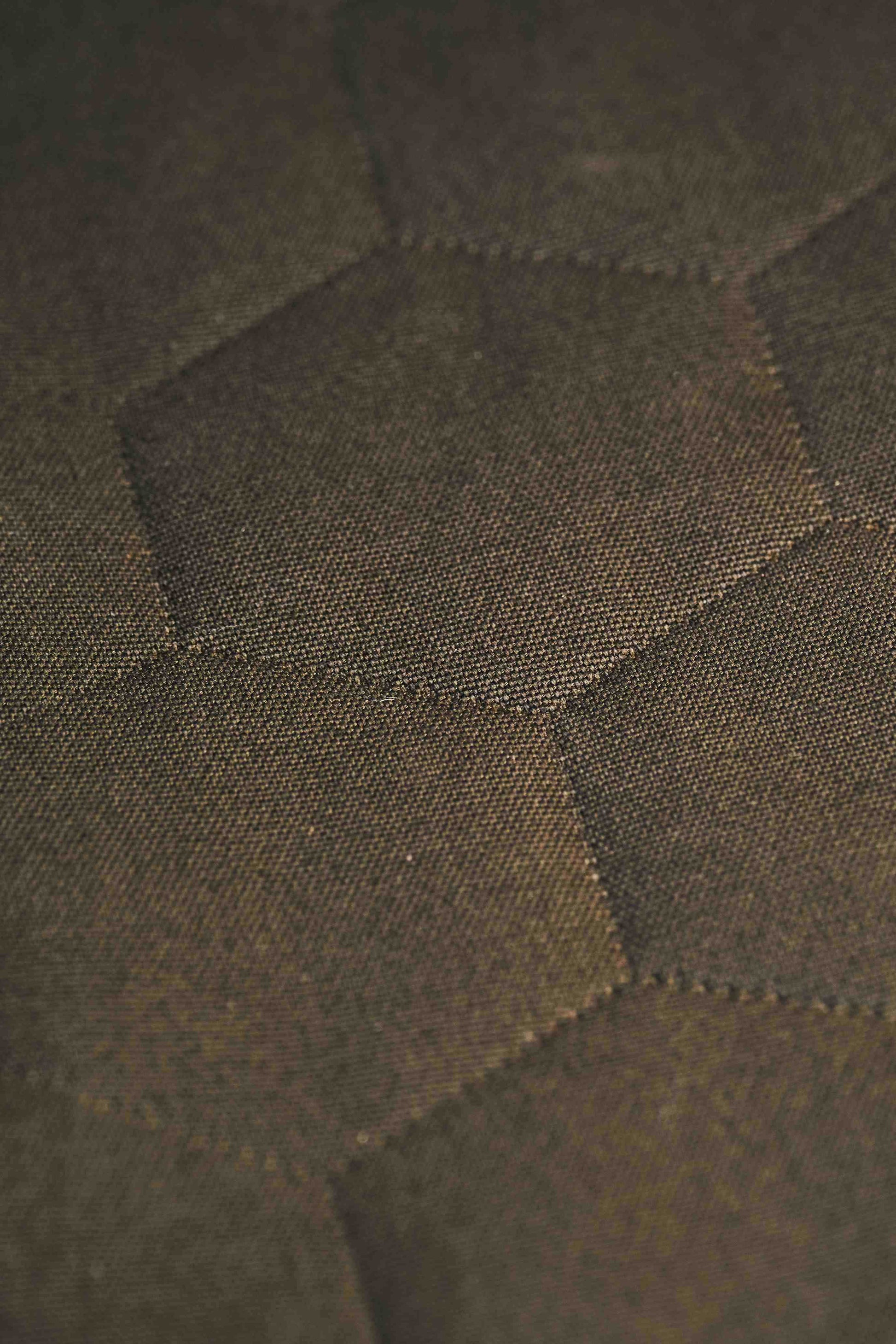 Close-up of a textured green fabric with geometric pattern