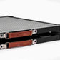 Black metal tray with brown leather straps on a white background