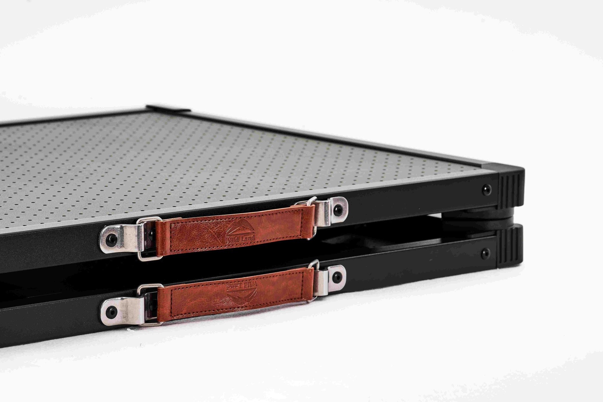 Black metal tray with brown leather straps on a white background