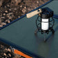 Portable LED camping lantern placed on a Wild Land MTS-C foldable aluminum camping table.